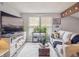 Inviting living room with a large television, comfortable seating, and sun-filled windows at 10961 Main Range Trl, Littleton, CO 80127