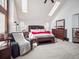 Bright primary bedroom with skylights, a king-size bed, and comfortable seating at 10961 Main Range Trl, Littleton, CO 80127