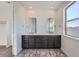 Bathroom featuring dual sinks, dark cabinets, and modern fixtures at 3147 S Russell St, Morrison, CO 80465