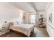 Serene bedroom with a large window, neutral color scheme, and decorative plants at 1265 Race St # 408, Denver, CO 80206