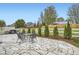 Backyard with flagstone patio, outdoor dining set, grill, and trees, perfect for entertainment and relaxation at 6711 Fraser Cir, Frederick, CO 80530