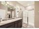 Bathroom featuring double sinks, large mirror, and walk-in shower with glass doors at 6711 Fraser Cir, Frederick, CO 80530