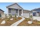 Beautifully landscaped front yard with a stone walkway leading to a covered porch at 6711 Fraser Cir, Frederick, CO 80530