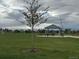 Community playground featuring picnic shelter, tables, and benches in a green space at 6711 Fraser Cir, Frederick, CO 80530