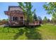 Relaxing backyard deck with mature tree, pergola, decorative railing, and well-maintained lawn at 10358 Kelliwood Way, Highlands Ranch, CO 80126