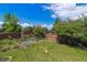 View of backyard featuring a lush lawn, wooden fence, and lovely landscaping at 10358 Kelliwood Way, Highlands Ranch, CO 80126