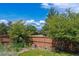View of backyard featuring a lush lawn, wooden fence, and gorgeous trees at 10358 Kelliwood Way, Highlands Ranch, CO 80126
