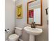 Powder room featuring pedestal sink, toilet, and decorative artwork at 10358 Kelliwood Way, Highlands Ranch, CO 80126