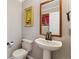 Stylish half-bathroom with modern fixtures, gray walls, white pedestal sink, and decorative art at 10358 Kelliwood Way, Highlands Ranch, CO 80126