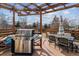 Back deck features stainless steel barbeque, dining table and chairs, and shaded umbrella at 10358 Kelliwood Way, Highlands Ranch, CO 80126