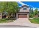 Exterior view of home featuring a two car garage, driveway and well maintained lawn and landscaping at 10358 Kelliwood Way, Highlands Ranch, CO 80126