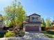 Charming two-story home featuring a well-manicured lawn, mature trees, and an attached two-car garage at 10358 Kelliwood Way, Highlands Ranch, CO 80126
