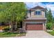 Charming two-story home featuring well-maintained landscaping, a two-car garage and a beautiful tree in the front yard at 10358 Kelliwood Way, Highlands Ranch, CO 80126