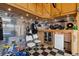 Garage featuring checkerboard flooring, slatwall, overhead storage, guitar, and a minifridge at 10358 Kelliwood Way, Highlands Ranch, CO 80126