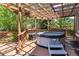 View of private, covered hot tub on backyard deck with wood pergola and decorative railing at 10358 Kelliwood Way, Highlands Ranch, CO 80126
