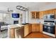 Kitchen features oak cabinetry, stainless steel appliances, and an eat-in counter at 10358 Kelliwood Way, Highlands Ranch, CO 80126