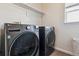 Laundry room featuring a modern washer and dryer set with a shelf for extra storage at 10358 Kelliwood Way, Highlands Ranch, CO 80126