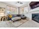 Comfortable living room featuring a sectional sofa, fireplace, and large windows for natural light at 10358 Kelliwood Way, Highlands Ranch, CO 80126