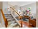 Bright living room featuring hardwood floors and stairs with carpeted treads at 10358 Kelliwood Way, Highlands Ranch, CO 80126