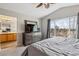 Bright main bedroom with a ceiling fan, dresser, and a large window with nature views at 10358 Kelliwood Way, Highlands Ranch, CO 80126