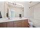 Well-lit bathroom featuring a large mirror, vanity with storage, and a shower-tub combo at 4865 Gibraltar St, Denver, CO 80249