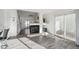 Bright living room featuring wood-look floors, a cozy fireplace, and sliding glass doors, seamlessly connecting spaces at 4865 Gibraltar St, Denver, CO 80249