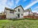 Spacious backyard featuring green grass, a patio set with an umbrella, and a view of neighboring houses at 718 Fairhaven St, Castle Rock, CO 80104