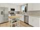 Bright kitchen featuring white cabinets, stainless steel appliances, and an island with a butcher block countertop at 718 Fairhaven St, Castle Rock, CO 80104