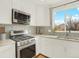A modern kitchen with stainless steel appliances, white cabinets, and a stylish backsplash to give a sleek look at 718 Fairhaven St, Castle Rock, CO 80104