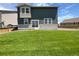 Spacious backyard with lush green lawn, fenced perimeter, and sliding glass door access at 12892 E 99Th Pl, Commerce City, CO 80022