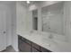 Bright bathroom featuring a double sink vanity with white countertop and modern chrome fixtures, and a large mirror at 12892 E 99Th Pl, Commerce City, CO 80022