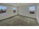 Bright bedroom with neutral carpet, three windows, and fresh white paint at 12892 E 99Th Pl, Commerce City, CO 80022