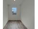 Modern bedroom featuring wood-look flooring, fresh white walls, and a bright window at 12892 E 99Th Pl, Commerce City, CO 80022