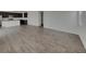 Open floor plan with wood-look floors and kitchen featuring an island with sink and stainless appliances at 12892 E 99Th Pl, Commerce City, CO 80022