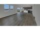 Bright open floor plan with wood-look flooring connecting the living and kitchen areas at 12892 E 99Th Pl, Commerce City, CO 80022