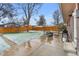 Spacious backyard with stone patio, mature trees, wooden fence, and furniture at 9360 Lowell Blvd, Westminster, CO 80031