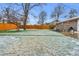 Spacious backyard with mature trees, wooden fence, and some snow at 9360 Lowell Blvd, Westminster, CO 80031