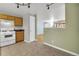 The kitchen area features wood cabinets, an electric range and views into another living area at 9360 Lowell Blvd, Westminster, CO 80031