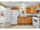 Functional kitchen with wood cabinets, tile flooring, and white appliances at 9360 Lowell Blvd, Westminster, CO 80031
