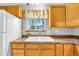 Bright kitchen sink with wood cabinets and a window looking out to the neighborhood at 9360 Lowell Blvd, Westminster, CO 80031
