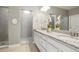 Bright bathroom featuring double sinks with granite countertops and a glass enclosed shower with a window at 13034 Bridge View Ln, Parker, CO 80134