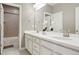 Well-lit bathroom with double sinks, white cabinetry, and a clear view of the shower/tub at 13034 Bridge View Ln, Parker, CO 80134