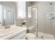 Bathroom featuring a glass enclosed shower with a seat, a sink, and a window providing natural light at 13034 Bridge View Ln, Parker, CO 80134