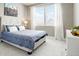 Comfortable bedroom with a large window, a painting, and a soft bed with patterned covers at 13034 Bridge View Ln, Parker, CO 80134