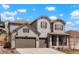 Charming two-story home with a three-car garage, stone accents, and a well-manicured front yard at 13034 Bridge View Ln, Parker, CO 80134
