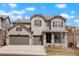 Charming two-story home with a three-car garage, stone accents, and a well-manicured front yard at 13034 Bridge View Ln, Parker, CO 80134
