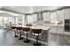 Bright kitchen with white cabinets, stainless steel appliances, and a large island with barstool seating at 13034 Bridge View Ln, Parker, CO 80134