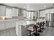 Bright kitchen with white cabinets, stainless steel appliances, and a large island with barstool seating at 13034 Bridge View Ln, Parker, CO 80134