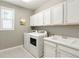Functional laundry room with white cabinets, sink and washer/dryer at 13034 Bridge View Ln, Parker, CO 80134