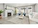 Cozy living room with a fireplace, a white sofa, and large windows that provide ample natural light at 13034 Bridge View Ln, Parker, CO 80134